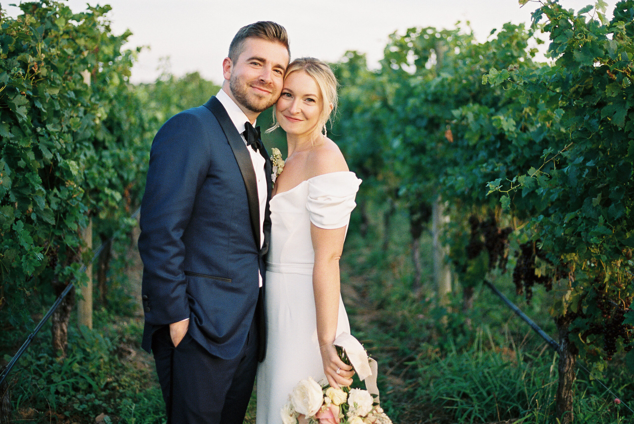 RGNY vineyard summer wedding bride and groom posing in the grape vines